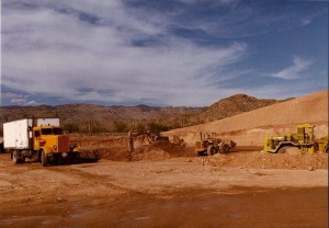 A construction site with a dump truck and a bulldozer operated by MGC Contractors.
