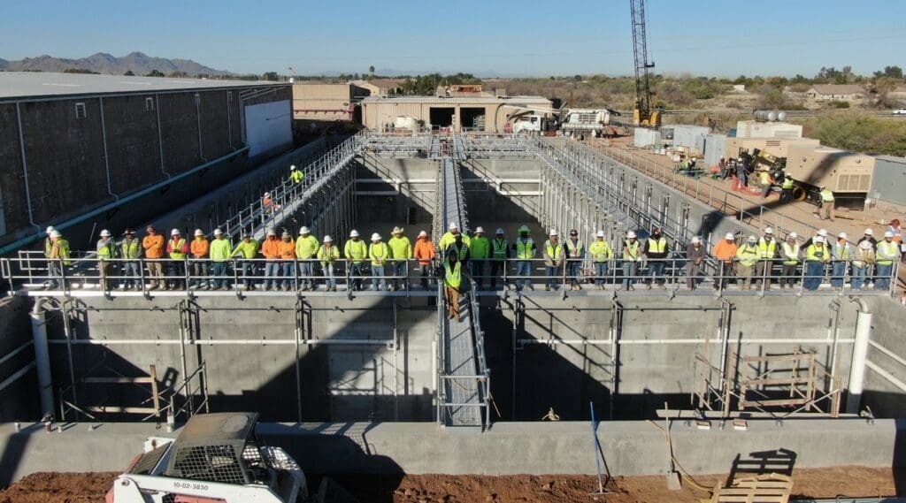 A group of construction workers standing in front of a concrete structure.
